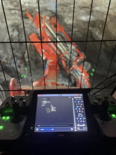 The control screen in a drill cab, with the boom beyond the cab guard.